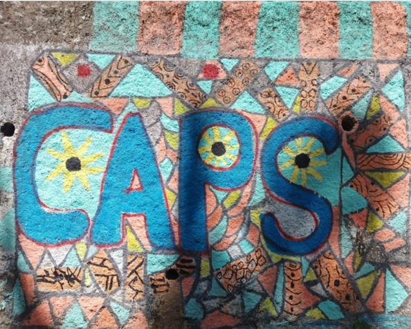Pintura colorida feita na parede com a palavra CAPS